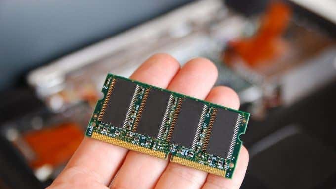 A person holding up a RAM module.